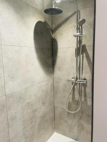 une cabine de douche à l'ombre d'un pommeau de douche dans l'établissement Villa Longeville avec Piscine Chauffée, à Longeville-sur-Mer