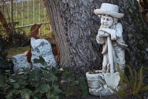 a statue of a boy in a hat next to a tree at Pension Wenger in Kirchheim im Innkreis