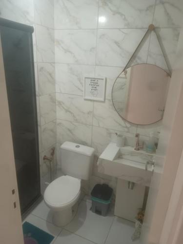 a bathroom with a toilet and a sink and a mirror at Condominio Mirante do Lago in Ananindeua