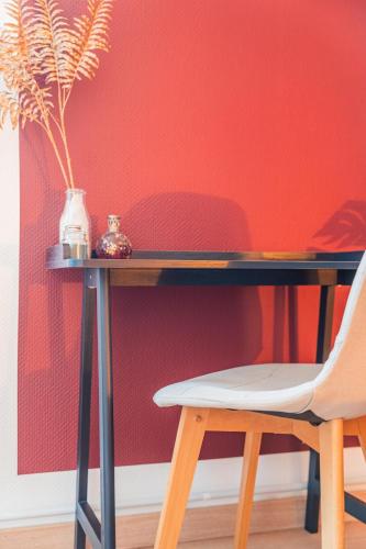 un bureau avec une chaise à côté d'un mur rouge dans l'établissement La Suite 112 - Large apartment - Garden Terrace, à Dachstein