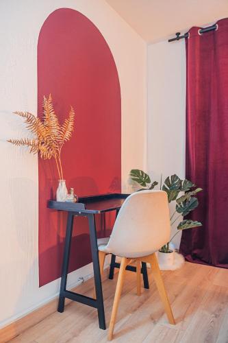 une table avec une chaise et un mur rouge dans l'établissement La Suite 112 - Large apartment - Garden Terrace, à Dachstein