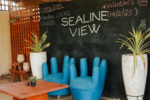 a chalkboard with blue chairs and plants in a room at Sealine View Hospitality Centre in Oblogo
