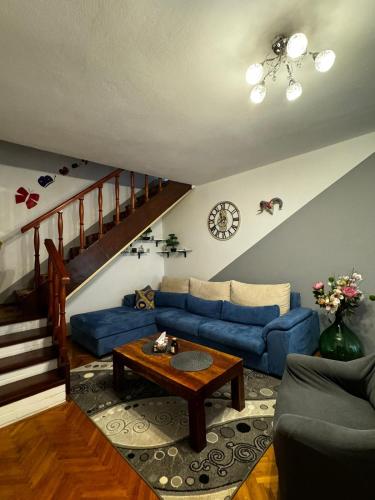 a living room with a blue couch and a table at Apartman Nonno Božo 2 in Fažana