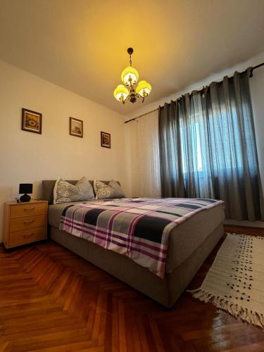 a bedroom with a bed and a chandelier at Apartman Nonno Božo 2 in Fažana