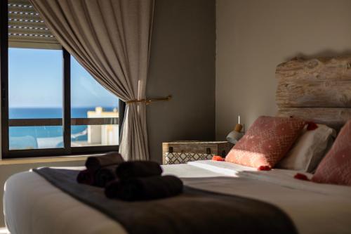 a bedroom with a bed with a view of the ocean at Apartamento Amara in Carvoeira