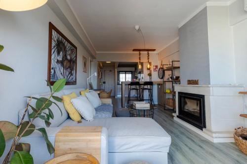 a living room with a couch and a fireplace at Apartamento Amara Ericeira in Carvoeira