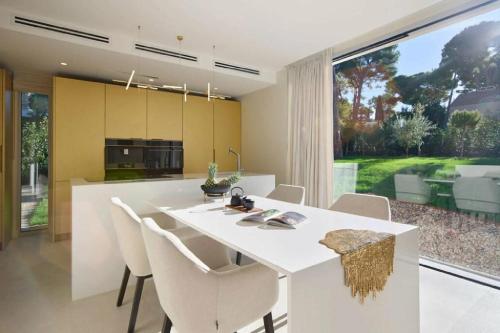 - une cuisine avec une table à manger blanche et des chaises dans l'établissement Contemporary Villa Vallon, à La Croix-Valmer