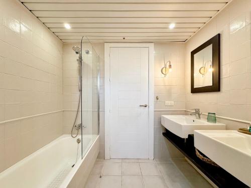 a white bathroom with a shower and a sink at CocoBeach Mojácar - 3 min a pie de Playa Macenas in Mojácar