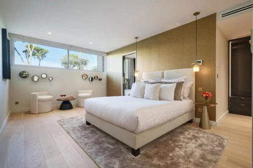 une chambre avec un grand lit et une grande fenêtre dans l'établissement Contemporary Villa Vallon, à La Croix-Valmer