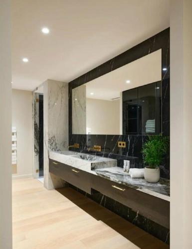 La salle de bains est pourvue d'un grand miroir et d'un lavabo. dans l'établissement Contemporary Villa Vallon, à La Croix-Valmer