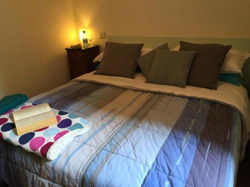 a bed with a book sitting on top of it at Appartamenti I Giardini Di Villa Melzi in Bellagio