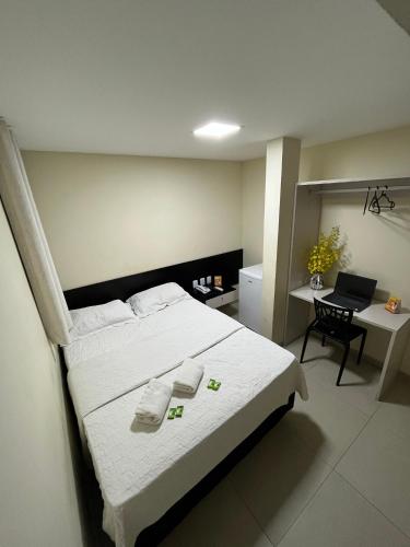 a bedroom with a large white bed and a desk at Grace Palace Hotel in Sobral