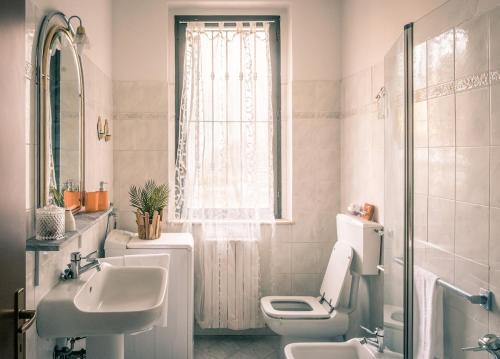 a bathroom with a sink and a toilet and a window at Fronte Ospedale, Parcheggio Gratis e Centro vicino in Piacenza