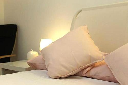 a pillow sitting on top of a bed with a table at La Villa in Salve