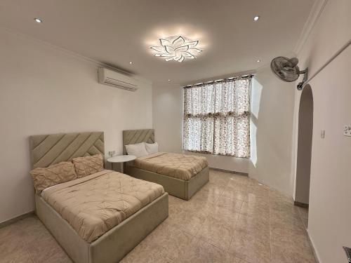 a living room with two beds and a window at International Abu-Dhabi Hostel Villa in Abu Dhabi