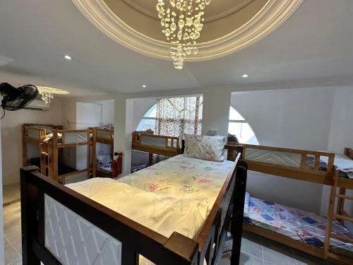 a bedroom with two bunk beds and a chandelier at International Abu-Dhabi Hostel Villa in Abu Dhabi