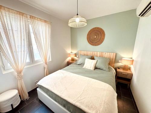 une chambre avec un lit et deux fenêtres dans l'établissement Appartement terrasse - 50m plage, à Canet