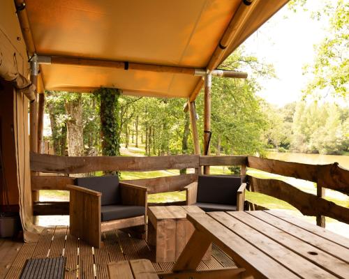 a wooden deck with two chairs and a table at Whaka Lodge in Seissan