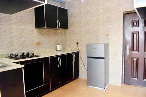 a kitchen with a white refrigerator in a room at Ike Service Apartments in Owerri