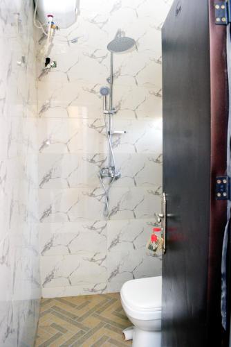 a bathroom with a white toilet in a room at Ike Service Apartments in Owerri
