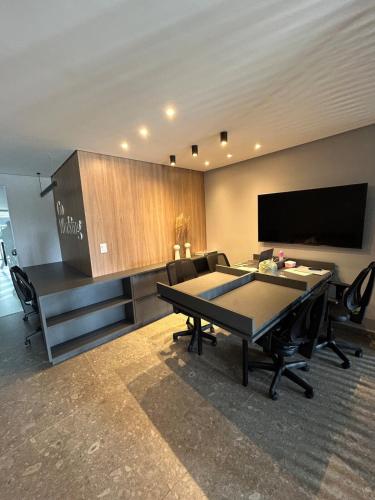 a conference room with a table and a flat screen tv at Melhores Flats - Relaxante, à beira-mar in Cabedelo