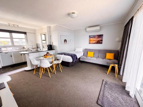 a bedroom with a bed and a table and chairs at Waikanae Beach Motel in Gisborne