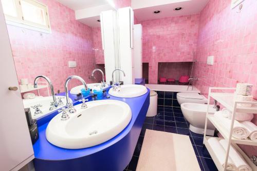 a pink bathroom with two sinks and two toilets at milano marittima luxury penthouse in Milano Marittima