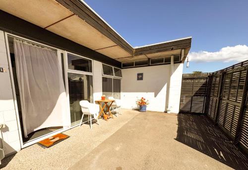 a patio of a house with a table and chairs at Waikanae Beach Motel in Gisborne