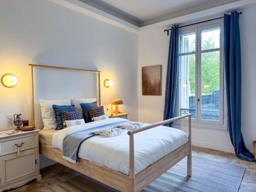 - une chambre avec un lit doté de rideaux bleus et d'une fenêtre dans l'établissement Bel appartement rénové - Jardin et Parking - DA, à Cannes
