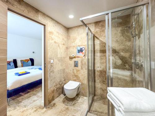 une salle de bain avec douche et toilettes et un lit dans l'établissement Bel appartement rénové - Jardin et Parking - DA, à Cannes