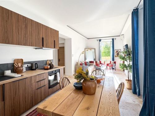 Il comprend une cuisine et une salle à manger avec une table en bois. dans l'établissement Bel appartement rénové - Jardin et Parking - DA, à Cannes