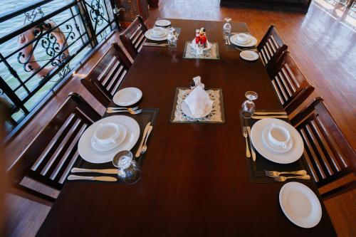 a wooden table with chairs and plates on it at Saphir Dahabiya luxury sailing boat Nile cruise Every Saturday from Luxor 4 or 7 nights in Luxor
