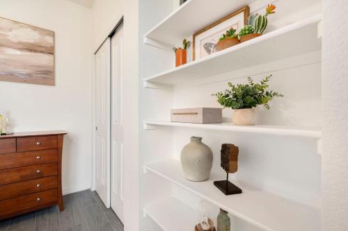 a room with white shelves with plants and a dresser at Timberline Retreat - King Bed, Fireplace & Pool! in Fort Collins