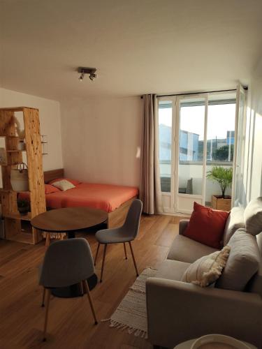 un salon avec un canapé et un lit dans l'établissement Cocon océan, à Saint-Hilaire-de-Riez