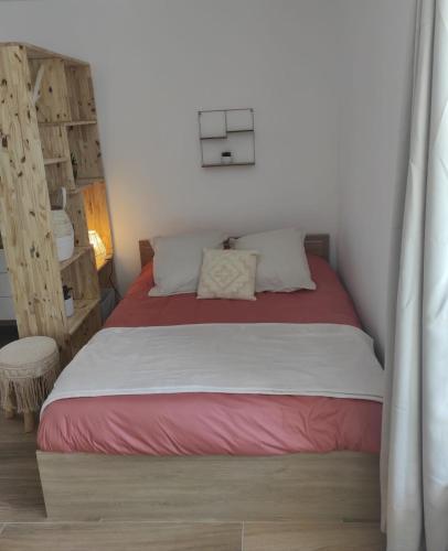 - une chambre dotée d'un lit avec une couverture rouge et blanche dans l'établissement Cocon océan, à Saint-Hilaire-de-Riez
