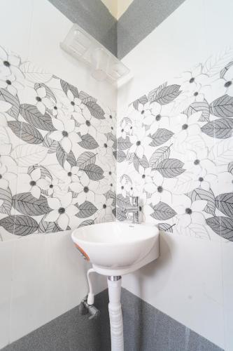 a bathroom with a white sink and floral wallpaper at Medhaa Homes Madurai in Madurai