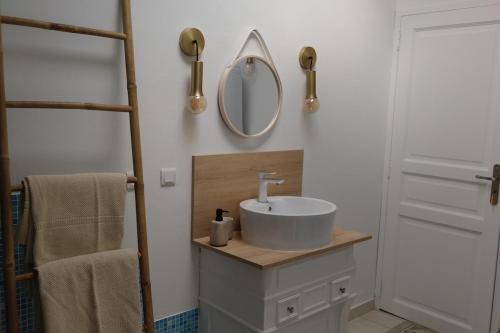 une salle de bain avec un lavabo et un miroir dans l'établissement L'Orée des Vignes, à Montcaret