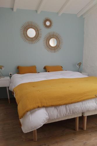 - une chambre avec un lit et deux miroirs sur le mur dans l'établissement L'Orée des Vignes, à Montcaret