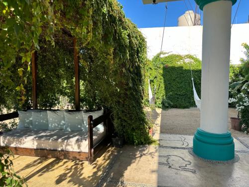 a bed in a ivy covered wall next to a pole at CABO BOHEMIA Tropical Garden Studios in Cabo San Lucas