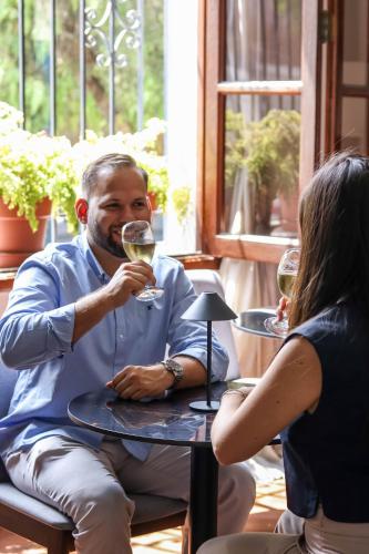 a man and a woman sitting at a table drinking wine at El Golf Hotel Boutique in Lima