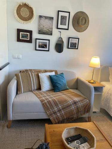 a living room with a couch and pictures on the wall at Casa Ligia in Vilamoura