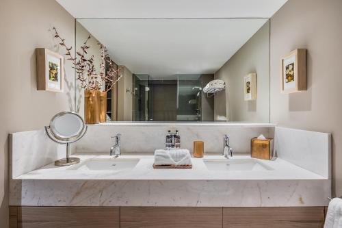 a bathroom with two sinks and a large mirror at Dominion Polanco in Mexico City