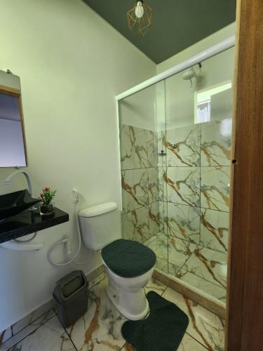 a bathroom with a toilet and a glass shower at Morada iluminada in Miguel Pereira