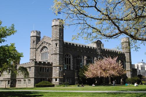 a large brick building with two towers on a field at Main Line Manor 3BR with King Beds & Patio & Backyard in Bryn Mawr