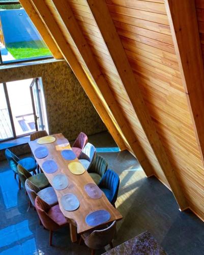 a long wooden table in a room with chairs at Qafqaz Wood Chalet in Gabala