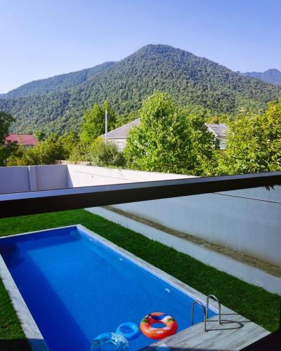 a swimming pool with a view of a mountain at Qafqaz Wood Chalet in Gabala