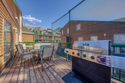 a grill on a deck with a table and chairs at Marble Canyon in Fairmont Hot Springs