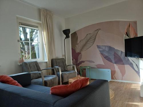 a living room with two couches and a tv at Natuur Appartement Dinxperlo in Dinxperlo