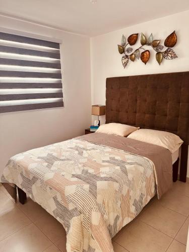 a bedroom with a large bed and a window at Departamento-Poliforum Feria Estadio Zona Piel. in León