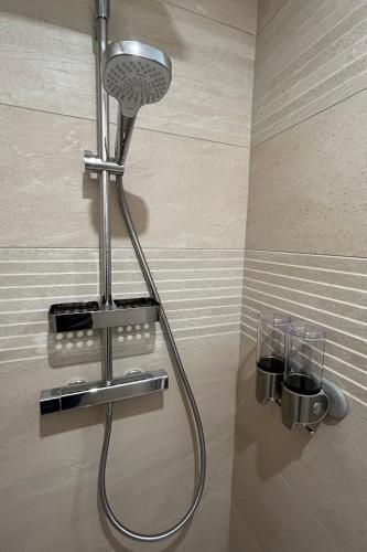 une douche avec pommeau de douche dans une salle de bain dans l'établissement Appartement cosy - proximité rue du Commerce, à Paris